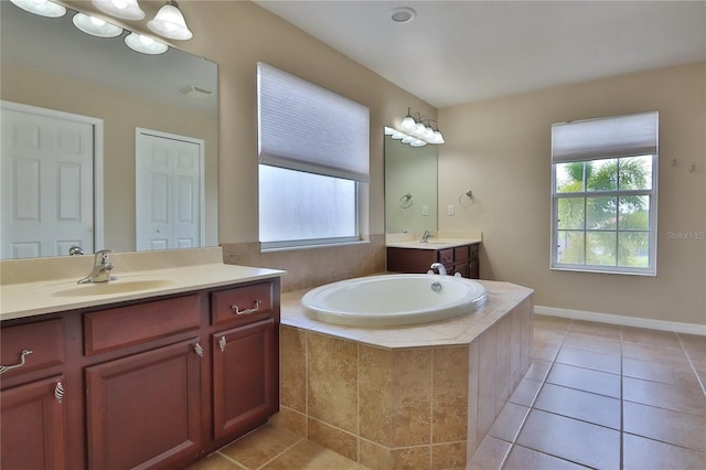 bathroom featuring tile patterned flooring, a bath, and a sink