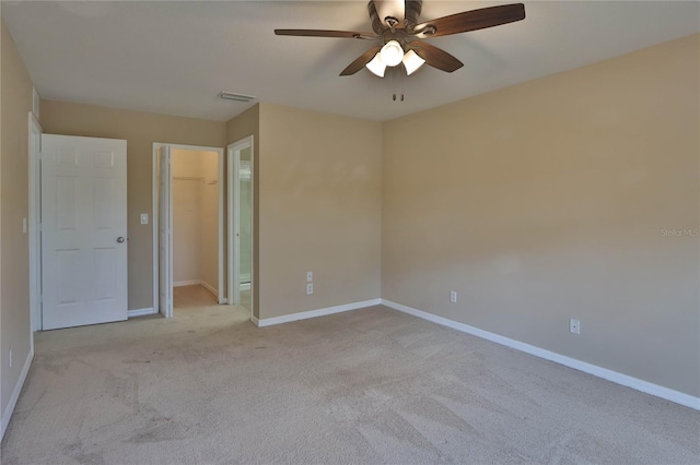 unfurnished bedroom featuring a spacious closet, baseboards, and carpet flooring