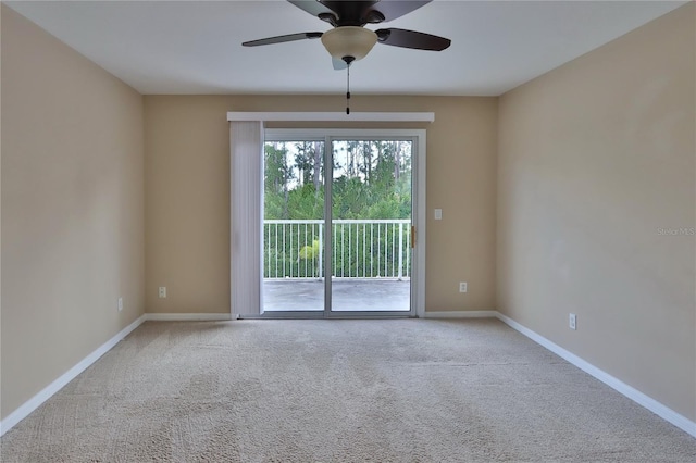 carpeted empty room featuring a ceiling fan and baseboards