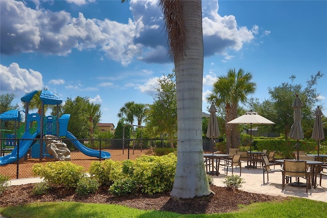 community play area featuring fence and a patio area
