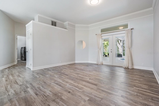 empty room featuring wood finished floors, visible vents, french doors, independent washer and dryer, and baseboards