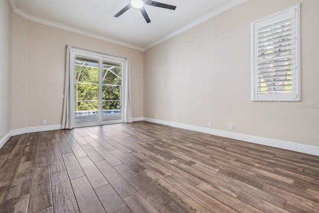 empty room with wood finished floors, crown molding, baseboards, and ceiling fan