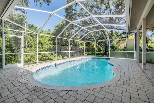 outdoor pool featuring a patio area and glass enclosure