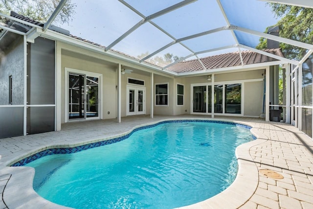 pool featuring glass enclosure, french doors, a ceiling fan, and a patio area