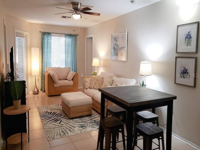 interior space featuring light tile patterned floors, visible vents, ceiling fan, and baseboards