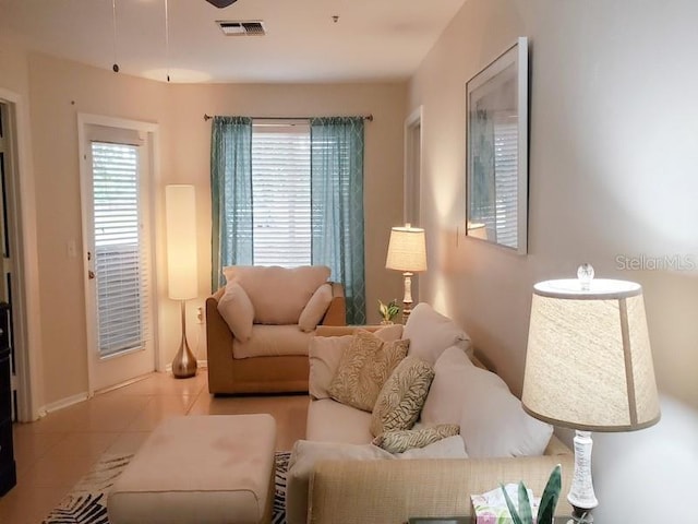 tiled living area featuring baseboards and visible vents