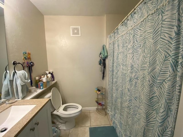 bathroom featuring tile patterned flooring, toilet, vanity, baseboards, and curtained shower