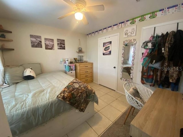 bedroom featuring light tile patterned flooring, ceiling fan, and a closet