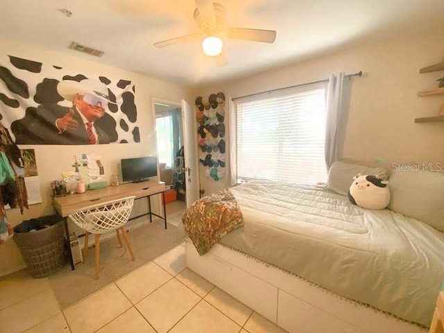 bedroom featuring light tile patterned flooring, visible vents, and ceiling fan