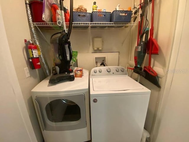 clothes washing area with washing machine and clothes dryer and laundry area