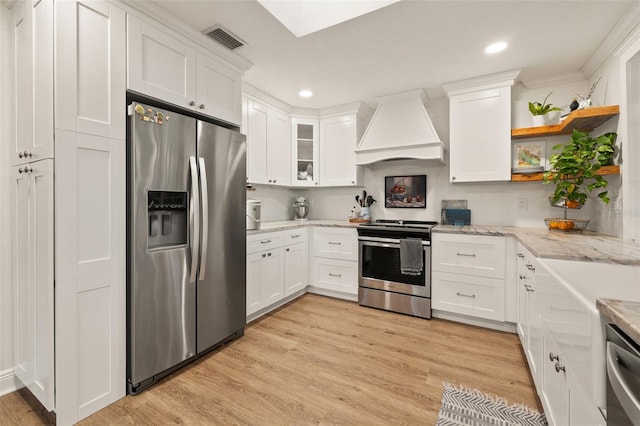 kitchen with white cabinets, stainless steel appliances, open shelves, visible vents, and custom range hood