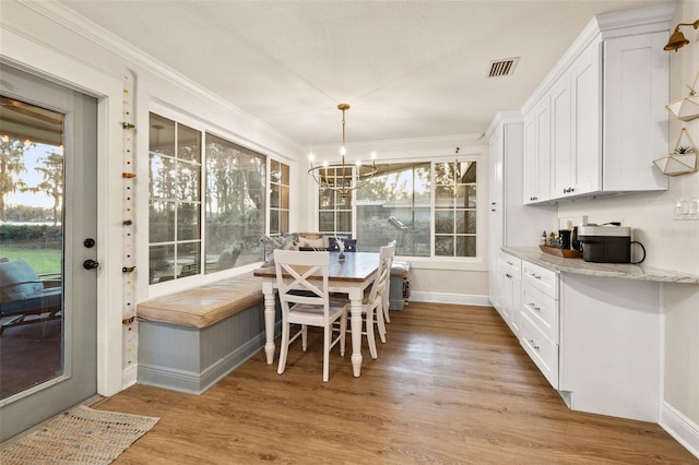 dining area with light wood-style floors, visible vents, baseboards, and an inviting chandelier