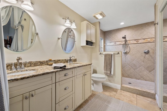 full bathroom with double vanity, a sink, a walk in shower, and toilet