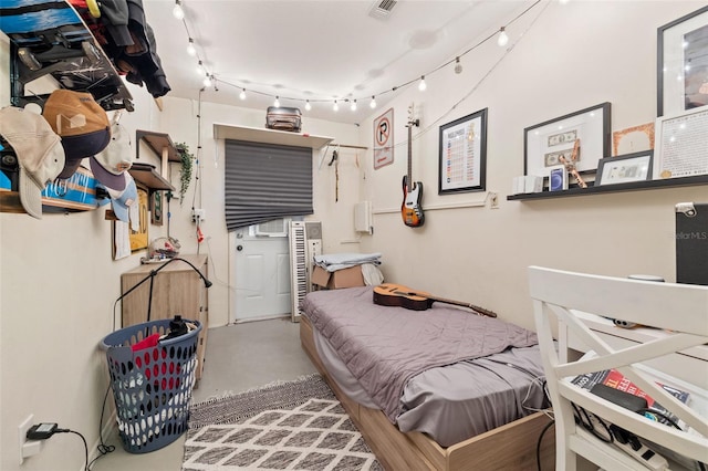 bedroom with concrete floors and visible vents