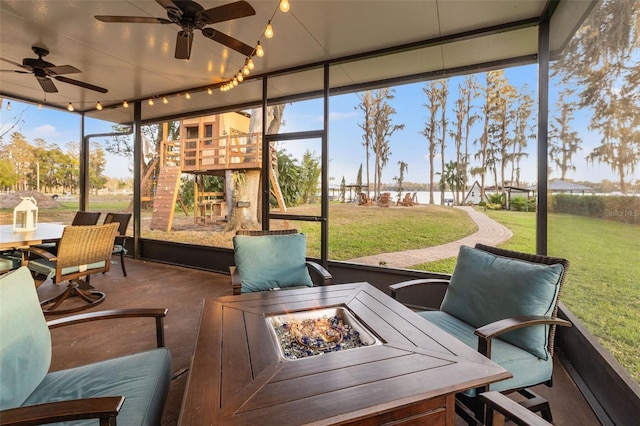 sunroom with ceiling fan, a fire pit, and outdoor dining space