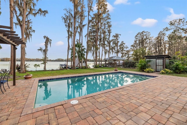 outdoor pool with a lawn, a gazebo, a water view, and a patio area