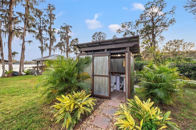 view of outbuilding with fence, a gate, and a water view