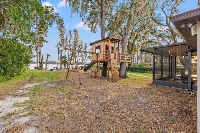 view of play area featuring a sunroom and a water view