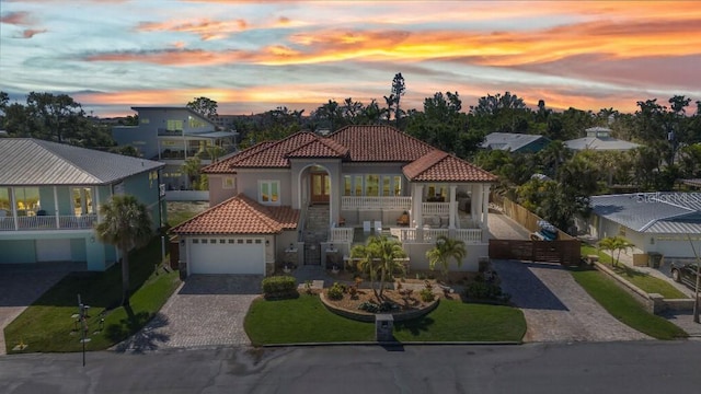 107 Sunset Dr, Nokomis, FL 34275 - mediterranean / spanish-style home with stucco siding, a tile roof, a porch, and decorative driveway