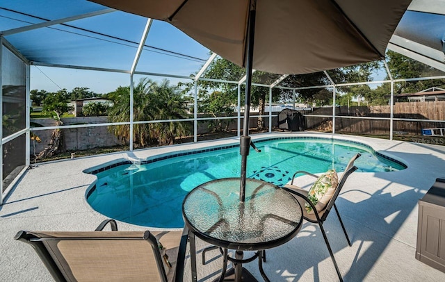 view of swimming pool featuring a patio area, glass enclosure, and a fenced backyard