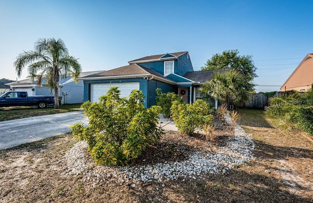 view of front of house featuring a shingled roof, an attached garage, concrete driveway, stucco siding, and fence