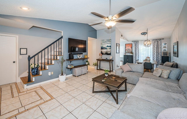 living area with stairway, baseboards, light tile patterned flooring, vaulted ceiling, and ceiling fan with notable chandelier