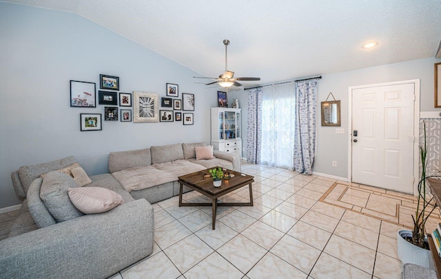 living room featuring light tile patterned floors, a ceiling fan, vaulted ceiling, and baseboards