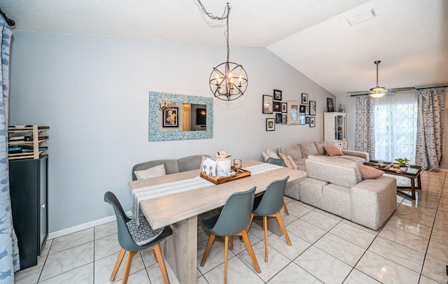 dining area with light tile patterned floors, ceiling fan with notable chandelier, baseboards, visible vents, and lofted ceiling