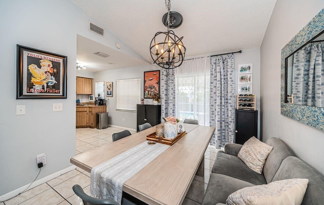 dining space with a chandelier, light tile patterned floors, visible vents, baseboards, and lofted ceiling