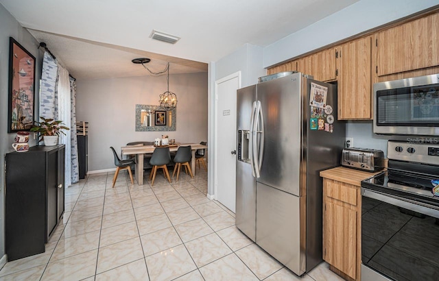 kitchen featuring a toaster, appliances with stainless steel finishes, baseboards, visible vents, and a notable chandelier