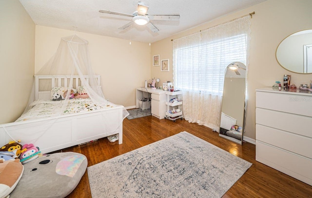 bedroom featuring wood finished floors, ceiling fan, and baseboards