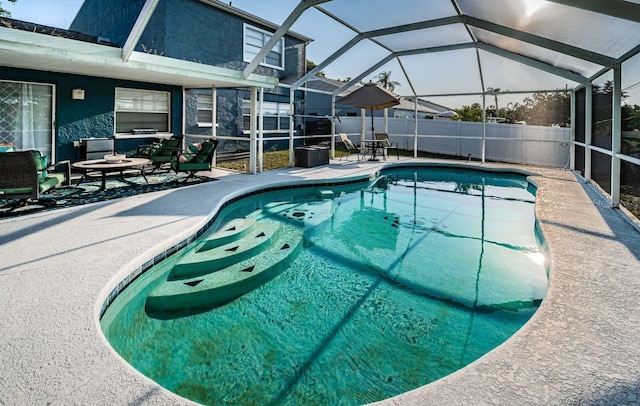 view of swimming pool featuring fence, a patio area, glass enclosure, and a fenced in pool