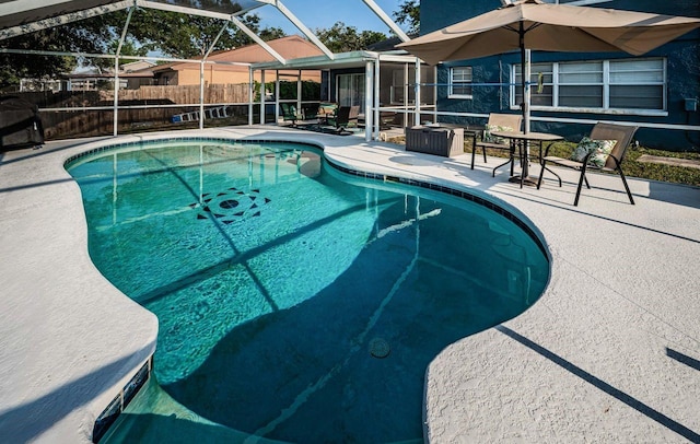 view of pool with a lanai, fence, a fenced in pool, and a patio area
