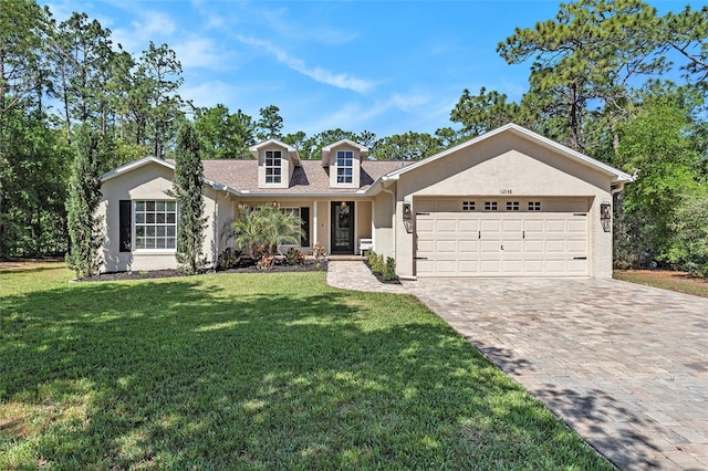 view of front of home featuring stucco siding, a front lawn, decorative driveway, and a garage