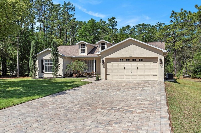 view of front of property featuring stucco siding, a front yard, decorative driveway, and a garage