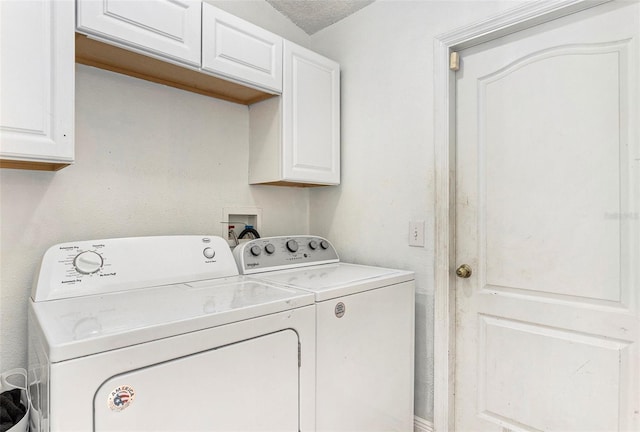 clothes washing area featuring cabinet space and separate washer and dryer