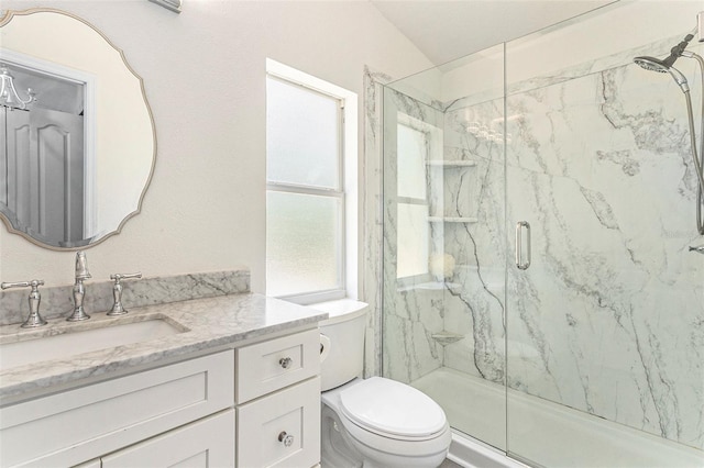 bathroom featuring a marble finish shower, vanity, and toilet