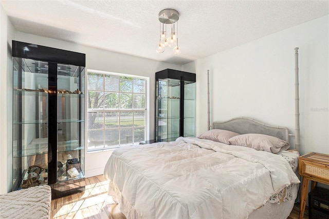 bedroom with wood finished floors and a textured ceiling