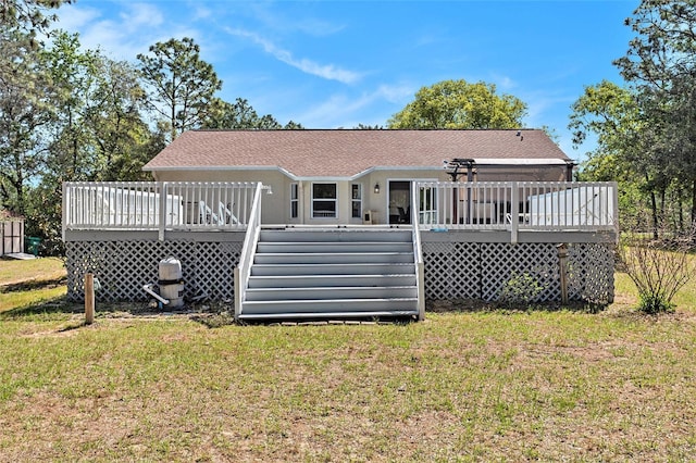 back of house with a yard, roof with shingles, and a deck