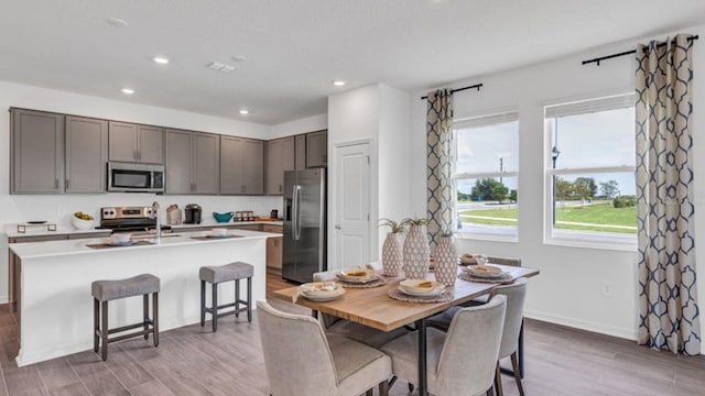 dining space featuring light wood-style flooring, baseboards, and recessed lighting