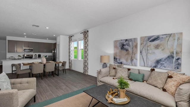 living area with visible vents, baseboards, wood finished floors, and recessed lighting