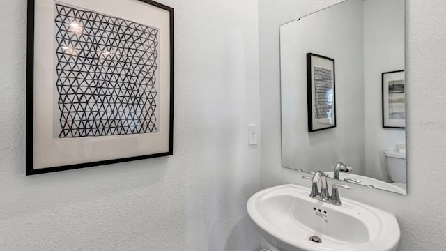 half bathroom with toilet and a sink