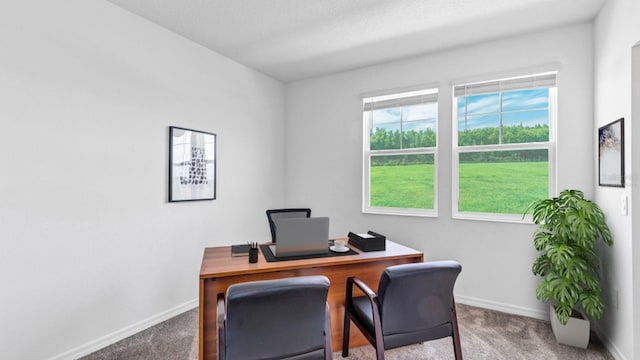 carpeted office space featuring baseboards