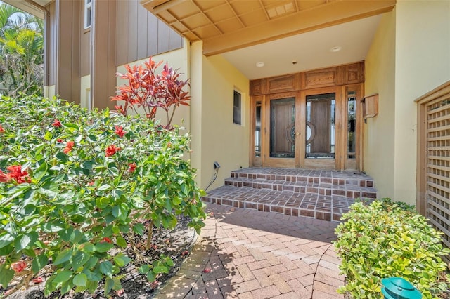 view of exterior entry with french doors and stucco siding