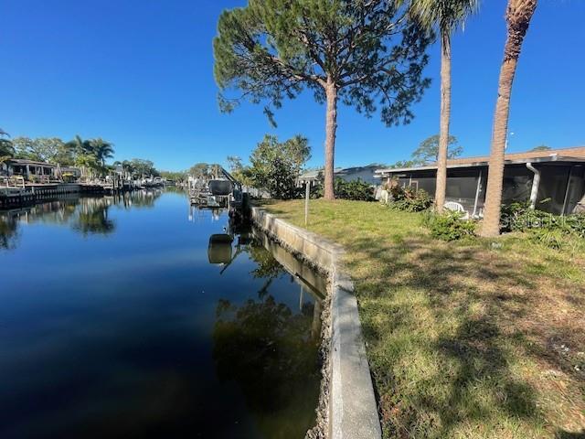 view of dock with a lawn and a water view