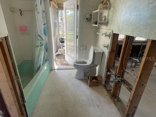 full bath with toilet and shower / tub combo with curtain
