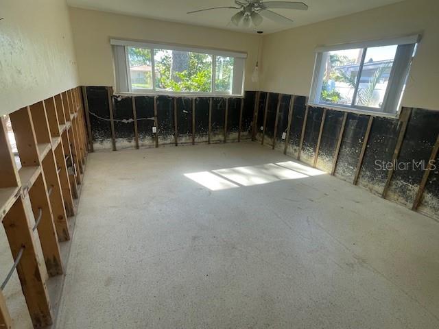 misc room with a ceiling fan, carpet floors, and a healthy amount of sunlight