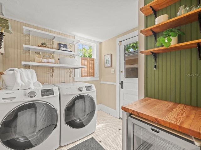 laundry room featuring independent washer and dryer, wooden walls, laundry area, and wine cooler