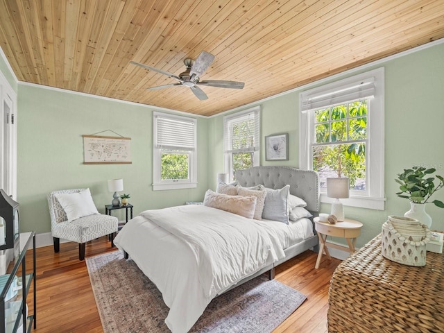 bedroom with wood finished floors, crown molding, and wood ceiling