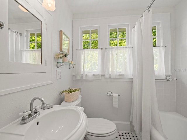 bathroom featuring a healthy amount of sunlight, toilet, and a sink